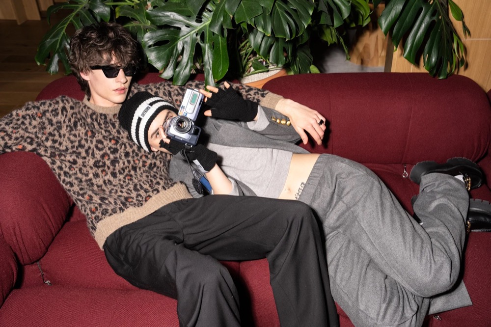 Zwei Models lümmeln auf einem roten Samtsofa, Drykorn-Kampagne HW/AW 23 in Bad Gastein