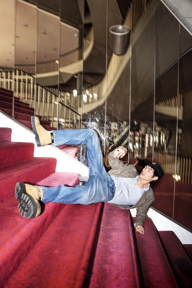 Zwei Models liegen auf einer Treppe mit rotem Teppich, Drykorn-Kampagne HW/AW 24 in einem Theater in Turin