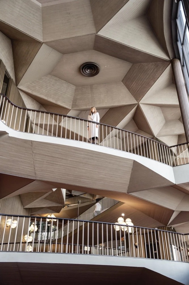 Modernistisches Foyer mit geschwungenen Treppen, Drykorn-Kampagne HW/AW 24 in einem Theater in Turin