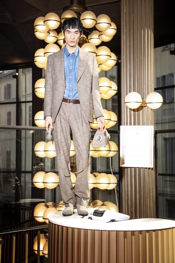 Model im beigen Anzug in einer beleuchteten Spiegelnische, Drykorn-Kampagne HW/AW 24 in einem Theater in Turin