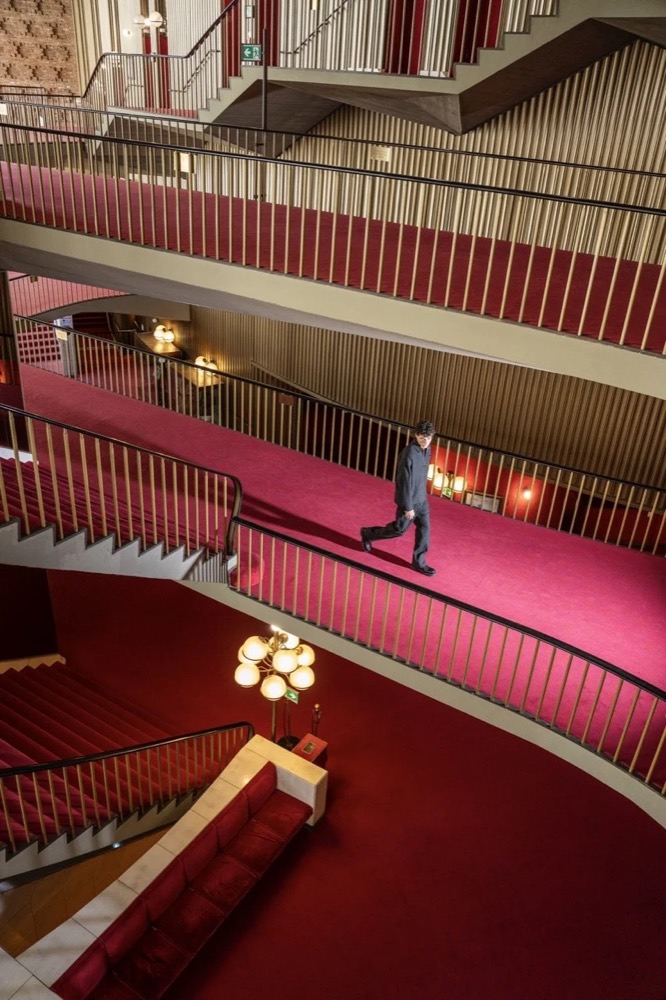 Model auf einem roten Balkon im Theater, Drykorn-Kampagne HW/AW 24 in einem Theater in Turin