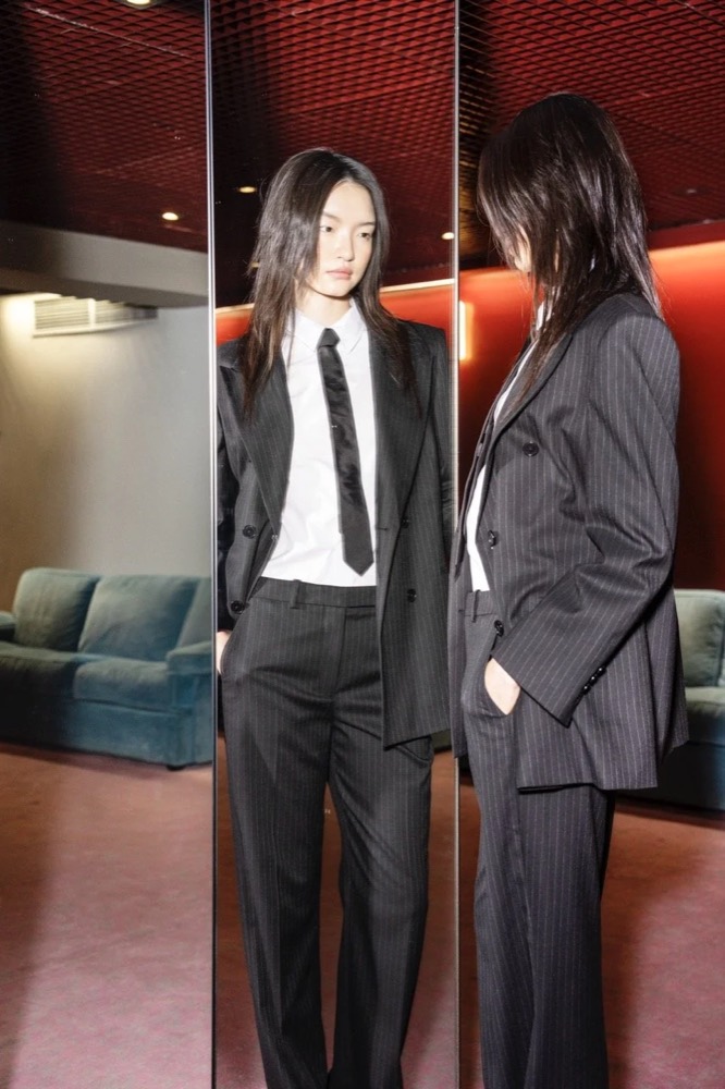 Zwei Models in dunklen Anzügen in einer Lounge, Drykorn-Kampagne HW/AW 24 in einem Theater in Turin
