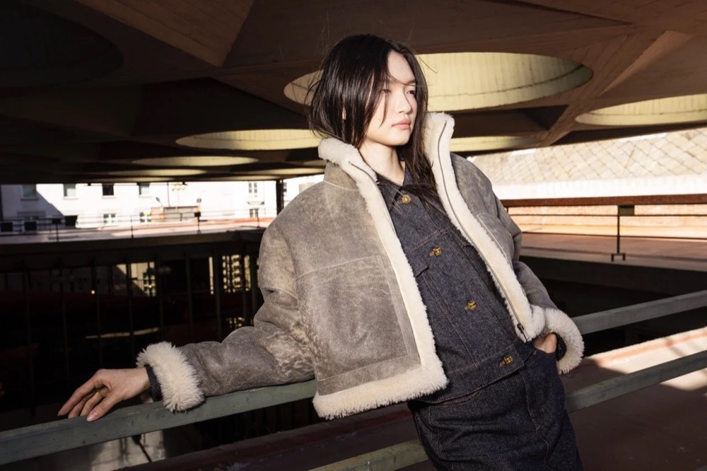 Model in Lammfelljacke in einem dunklen Flur, Drykorn-Kampagne HW/AW 24 in einem Theater in Turin