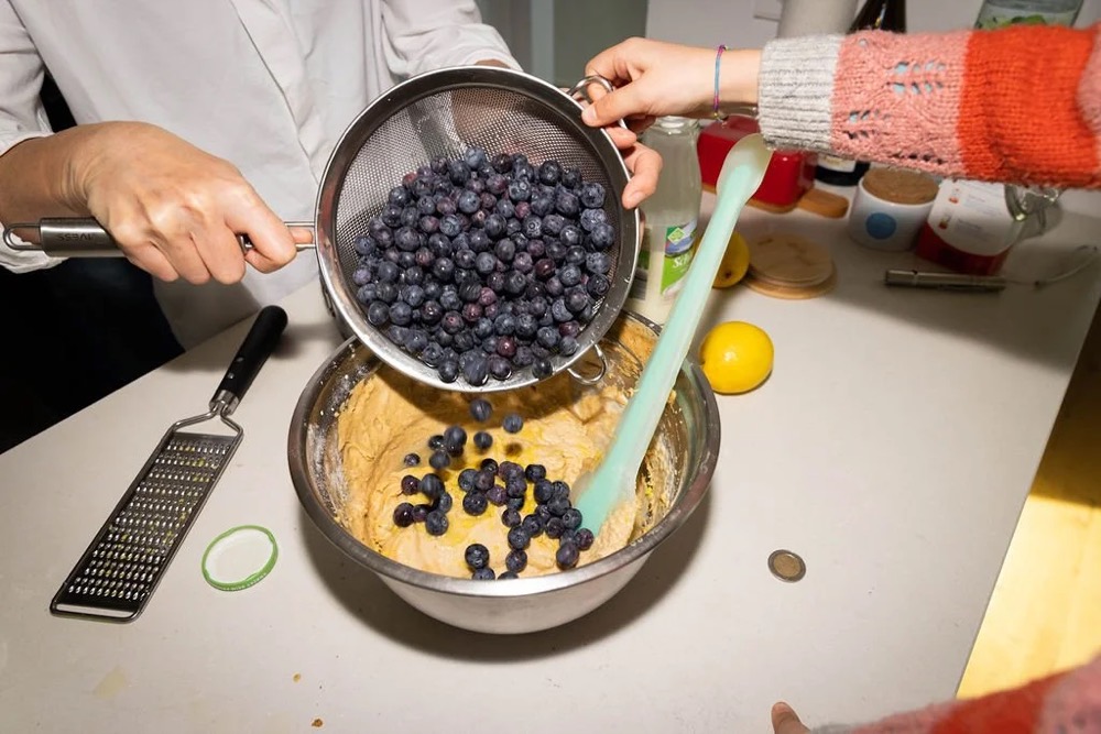 Blaubeeren werden aus einem Sieb in eine Schüssel geschüttet, Bespoke-Shooting für ING