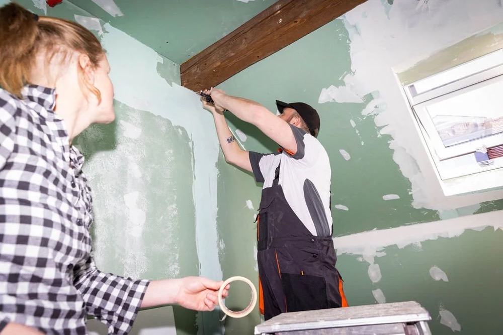 Frau und Mann streichen eine Wand grün, Bespoke-Shooting für ING