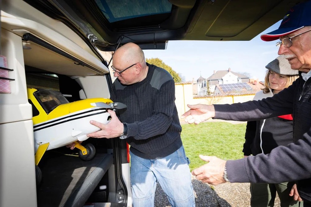Mann lädt Werkzeug in den Kofferraum eines Autos, Bespoke-Shooting für ING