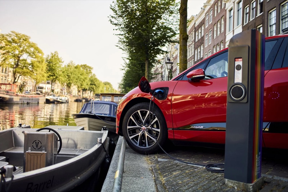 Roter Jaguar I-PACE an einer Ladestation an einer Amsterdamer Gracht