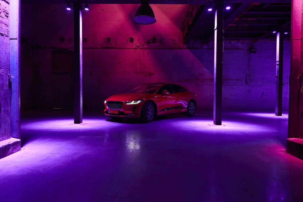 Roter Jaguar I-PACE in einer dunklen Garage mit lila Licht