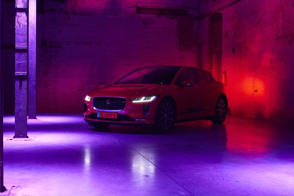 Roter Jaguar I-PACE in rotem und lila Licht in einer Tiefgarage