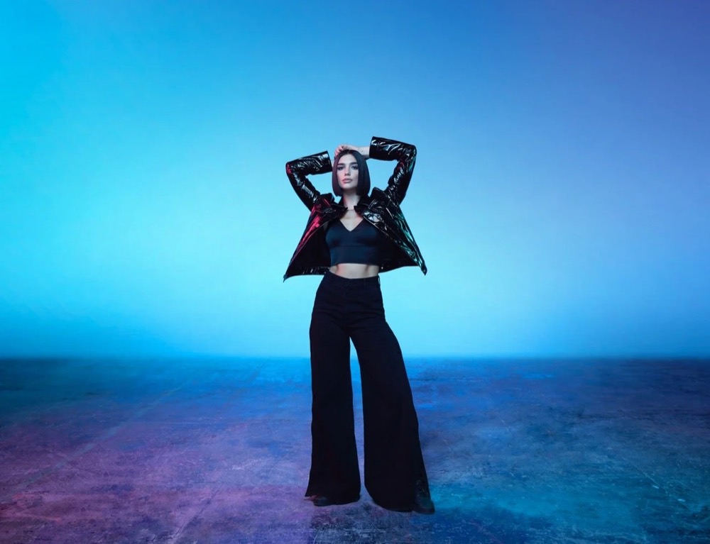 Dua Lipa im schwarzen Outfit vor blauem Hintergrund, Jaguar The Pace