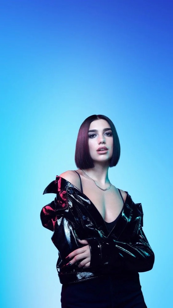 Porträt von Dua Lipa in schwarzer Lackjacke vor Hellblau, Jaguar The Pace