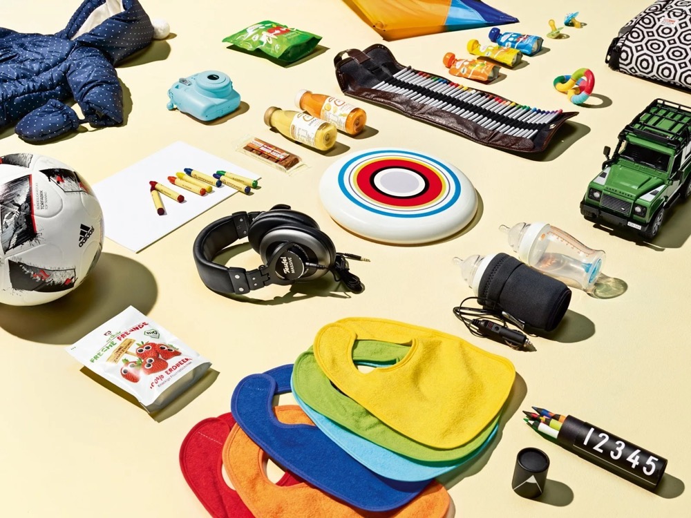 Nahaufnahme von Familienausrüstung mit Frisbee, Lätzchen und einem Spielzeug-Land-Rover, Land Rover Discovery Adventure Series