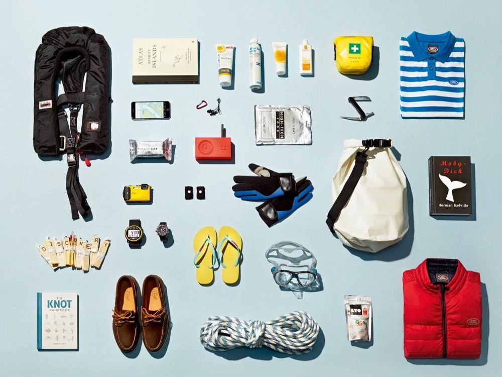 Flatlay mit Segelausrüstung, Rettungsweste, Tau und Bootsschuhen, Land Rover Discovery Adventure Series