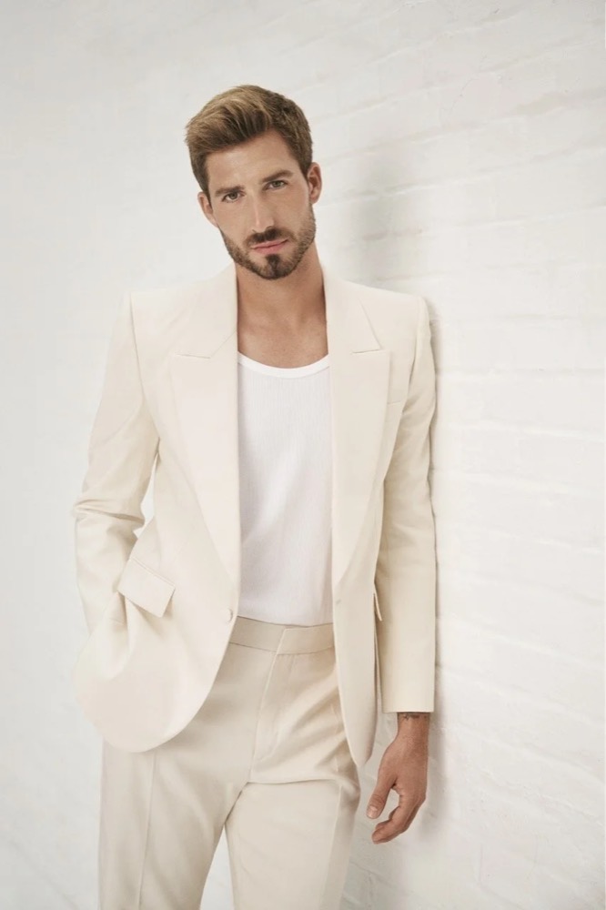 Kevin Trapp im cremefarbenen Anzug, Ganzkörperporträt für Merz Aesthetics
