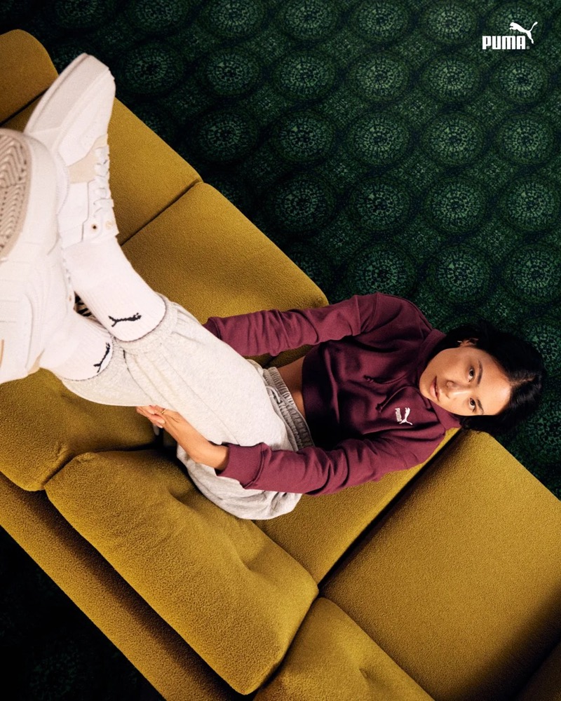 Model im Puma-Sweatshirt auf einem grünen Sofa liegend, Puma AW23