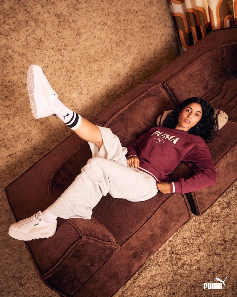 Model in Puma-Sneakern auf einem Ledersofa liegend, Puma AW23