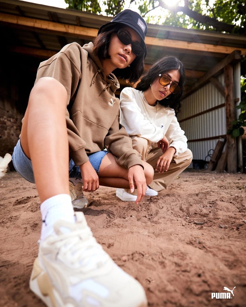 Zwei Models in Puma-Outfits sitzen in einer Scheune, Puma AW23