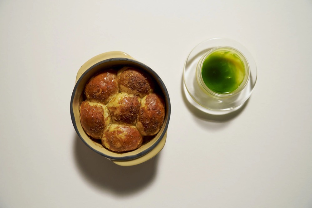 Brot in einer Kupferpfanne neben einem grünen Dip, Foodfotografie für das Restaurant Rausch