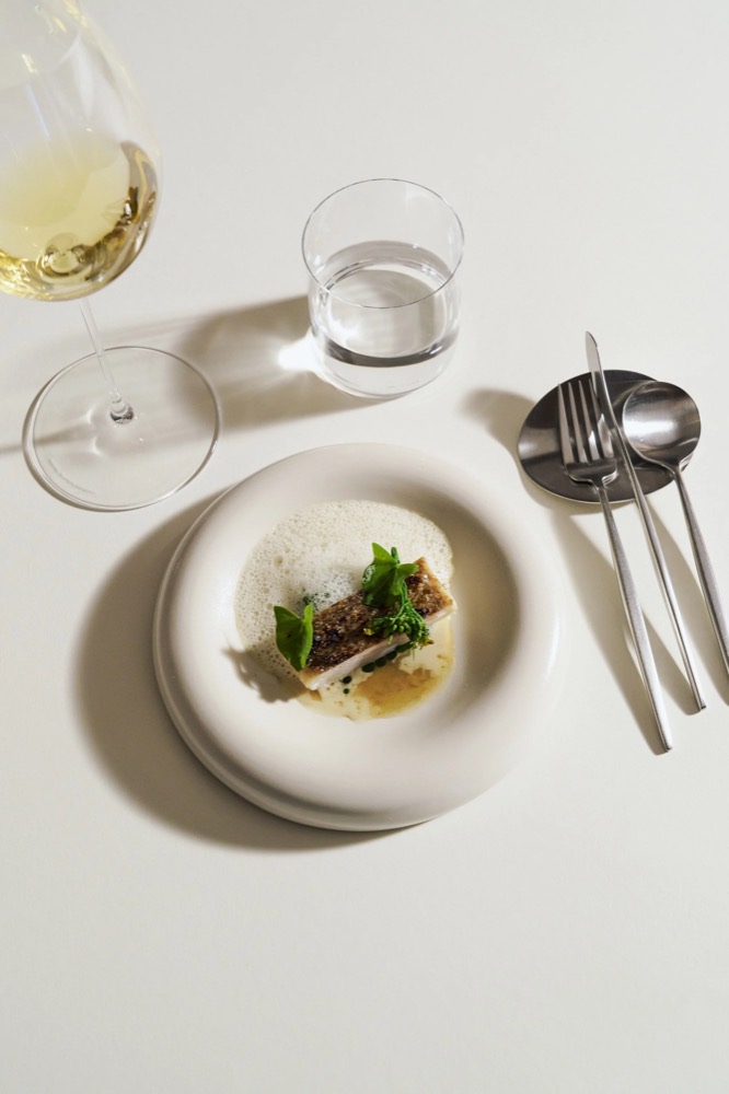 Hauptgang mit Weißwein und Besteck von oben, Foodfotografie für das Restaurant Rausch