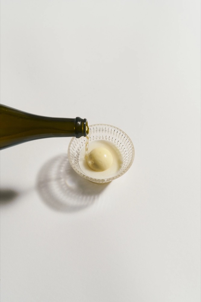 Weißwein wird in ein Glas eingeschenkt, Foodfotografie für das Restaurant Rausch