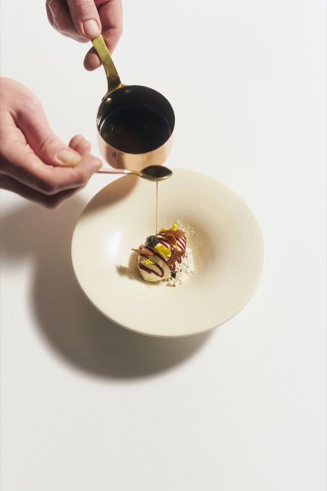 Sauce wird über ein Dessert gegossen, Foodfotografie für das Restaurant Rausch
