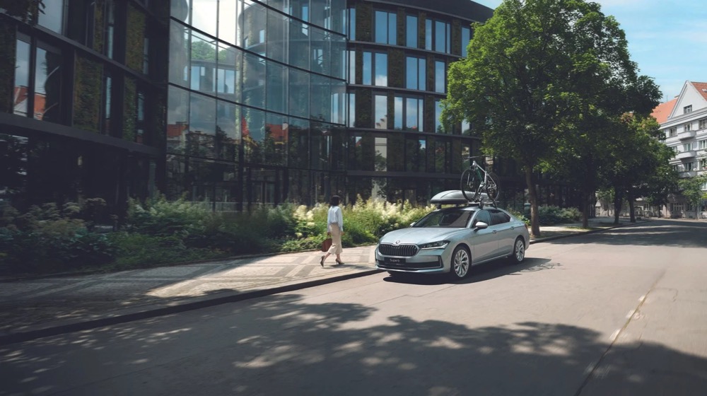 Škoda Superb fährt durch eine Stadtstraße, Škoda-Zubehörkampagne