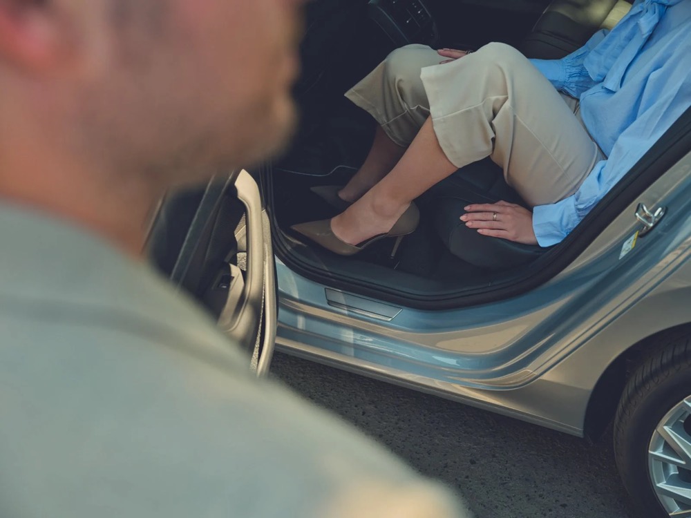 Mann steigt aus einem Škoda Superb, Detail der Einstiegsleiste, Škoda-Zubehörkampagne