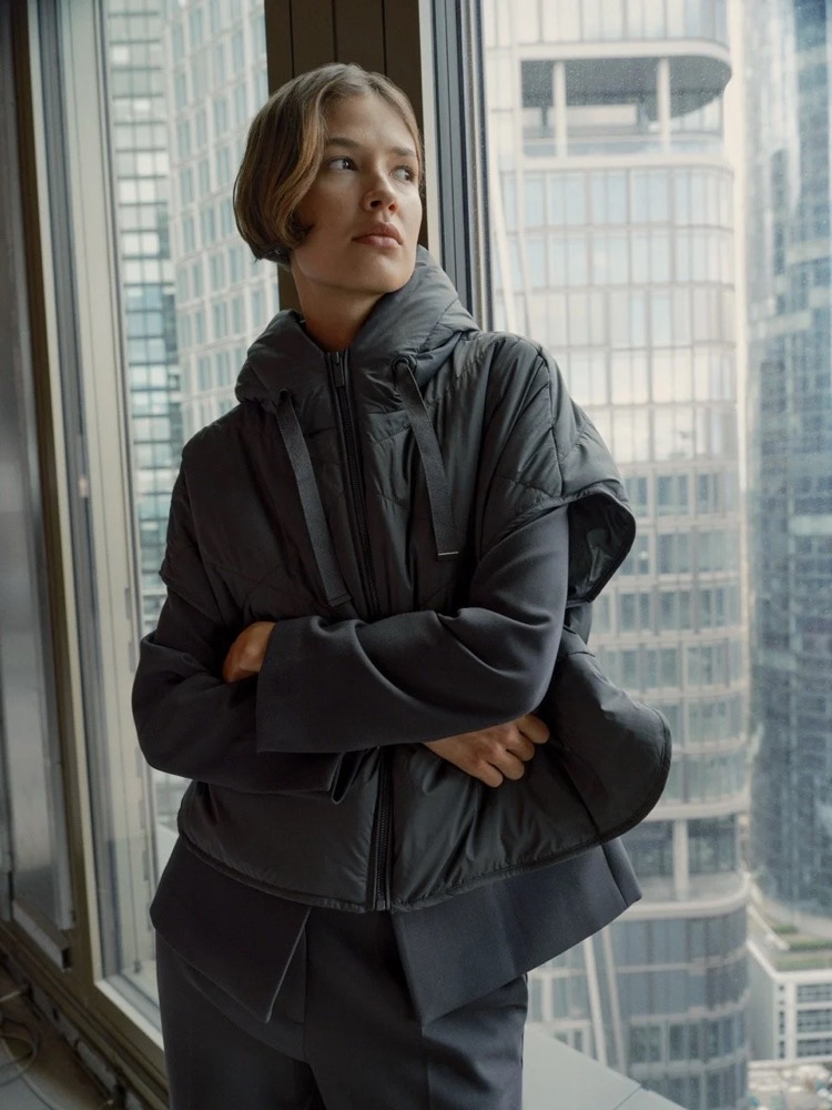 Model in Steppjacke am Bürofenster mit Blick auf die Skyline, Fashion-Shooting für someday. in Frankfurt