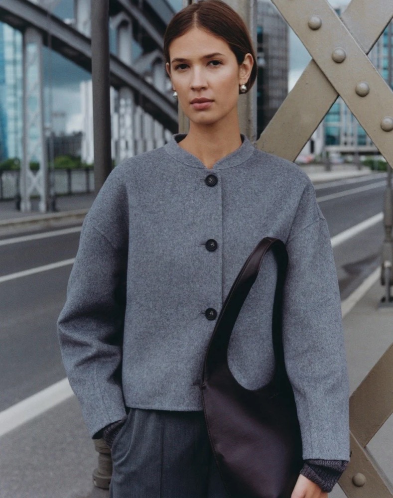 Model in grauem Cardigan mit schwarzer Tasche auf einer Brücke, Fashion-Shooting für someday. in Frankfurt