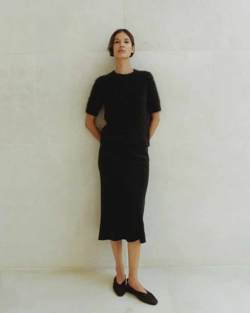 Model im schwarzen Strickkleid vor einer weißen Wand, Fashion-Shooting für someday. in Frankfurt