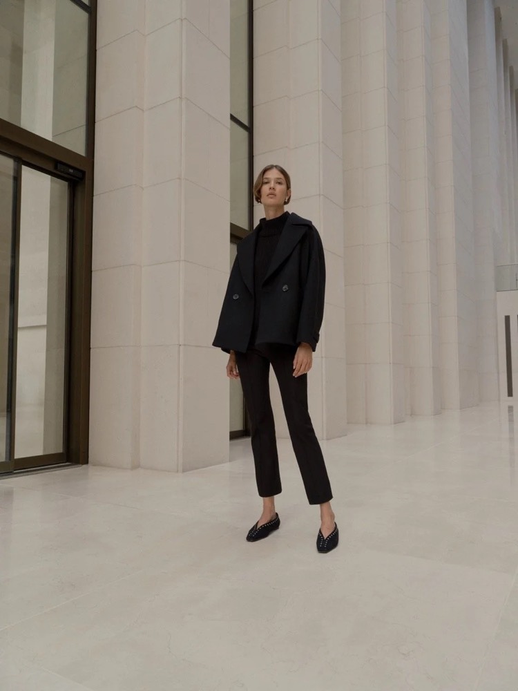 Model in Schwarz in einer hellen Steinlobby, Fashion-Shooting für someday. in Frankfurt