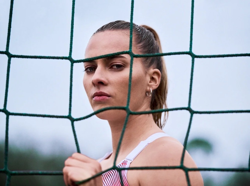 Laura Freigang schaut durch ein Fußballnetz, Under Armour