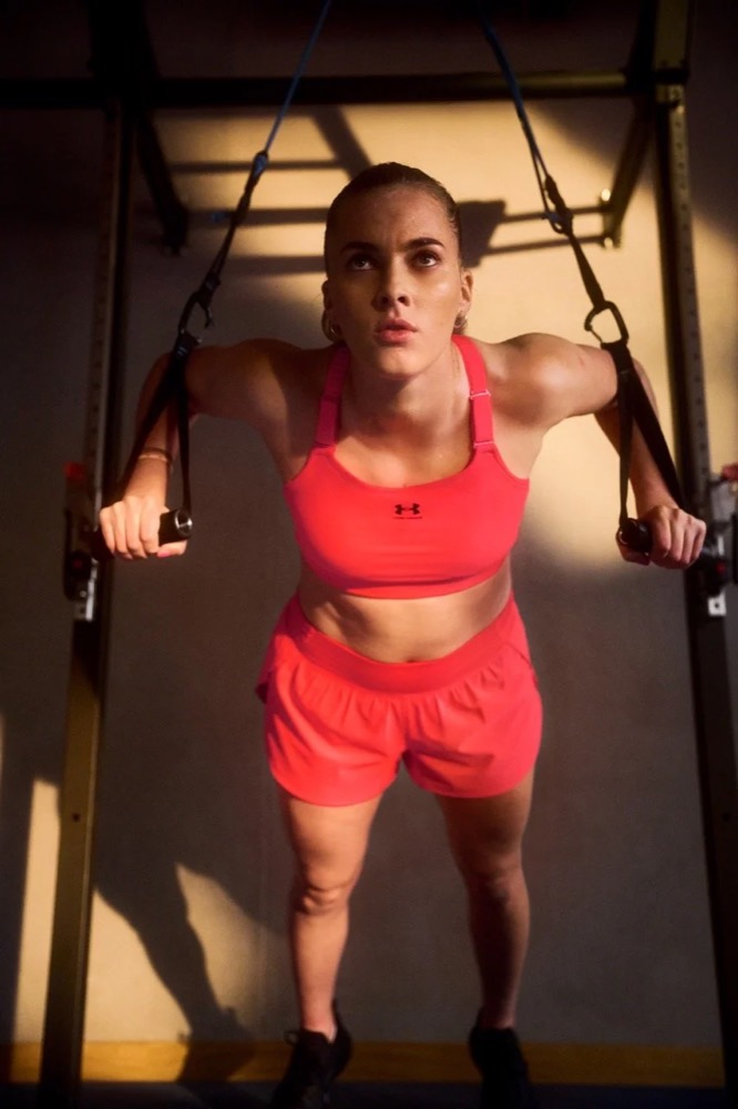 Laura Freigang trainiert in pinker Under-Armour-Sportkleidung an einem Rack im Gym